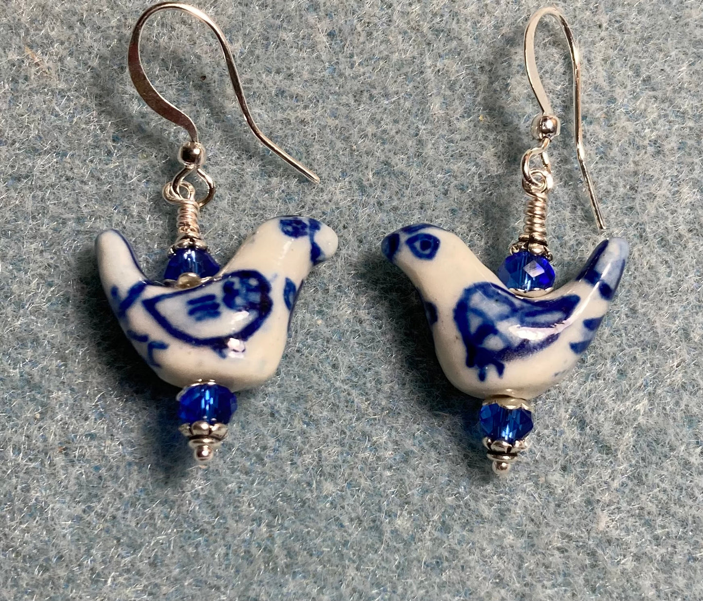 Small dark blue and white ceramic bird bead earrings adorned with dark blue Chinese crystal beads.