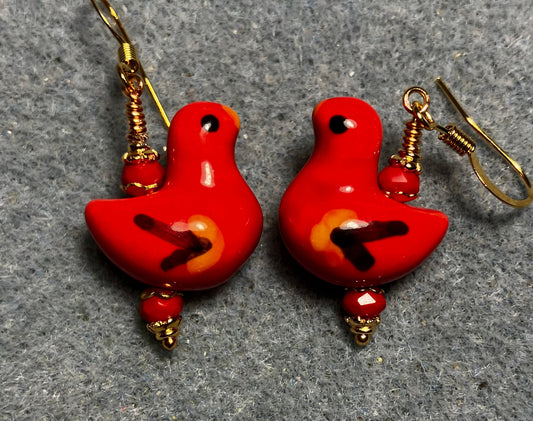 Red, black, and yellow ceramic duck bead earrings adorned with red Chinese crystal beads.