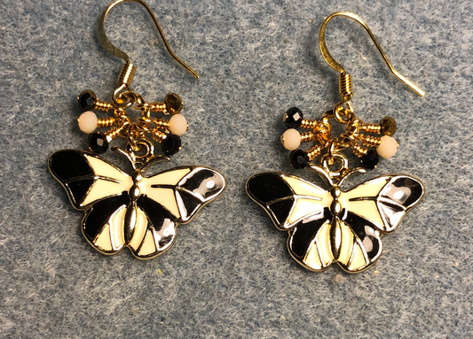 White and black enamel butterfly charm earrings adorned with tiny dangling black, white, and gold Chinese crystal beads.