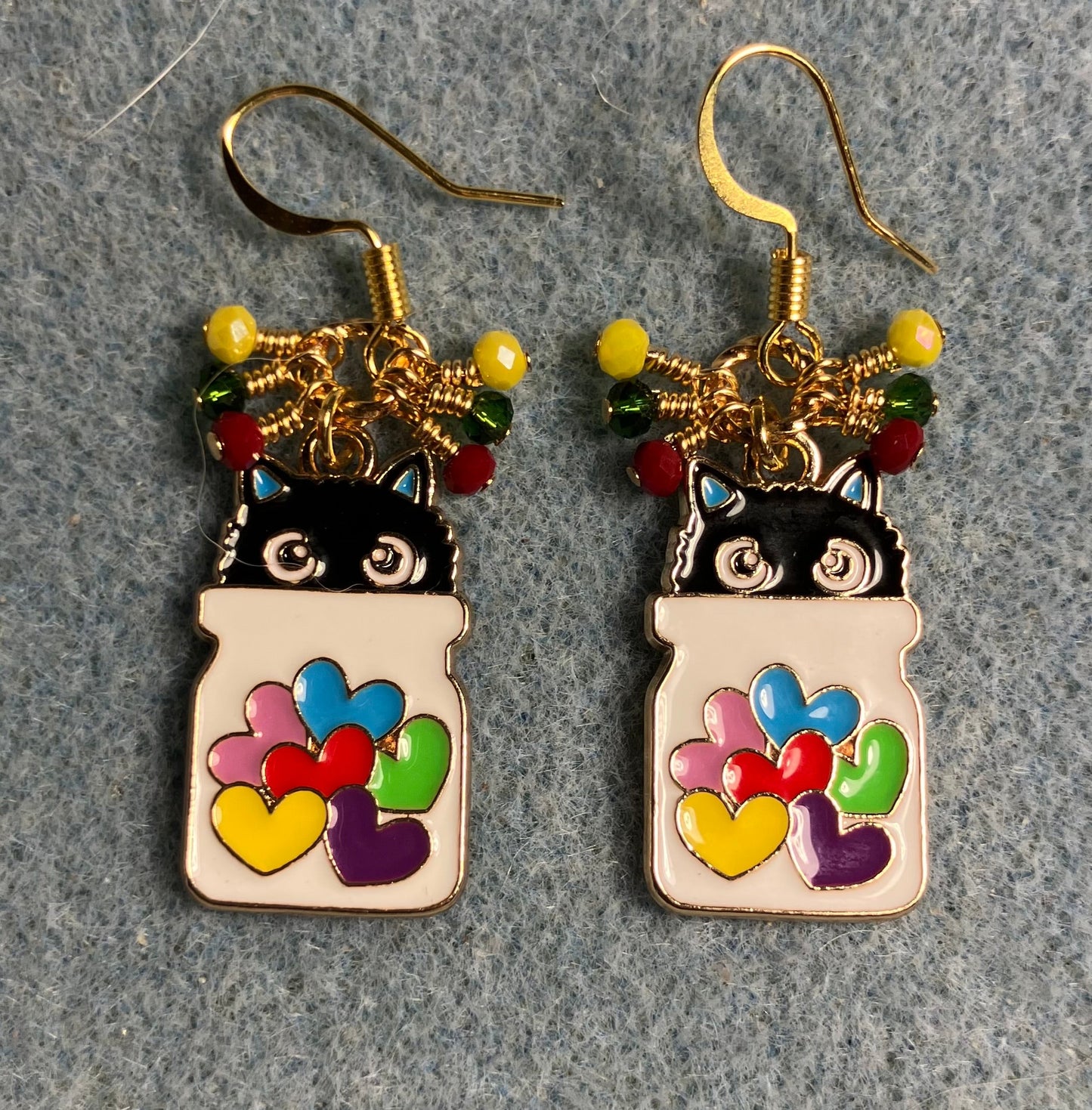 White, black, red, yellow, and green enamel cat charm earrings adorned with tiny dangling red, yellow, and green Chinese crystal beads.