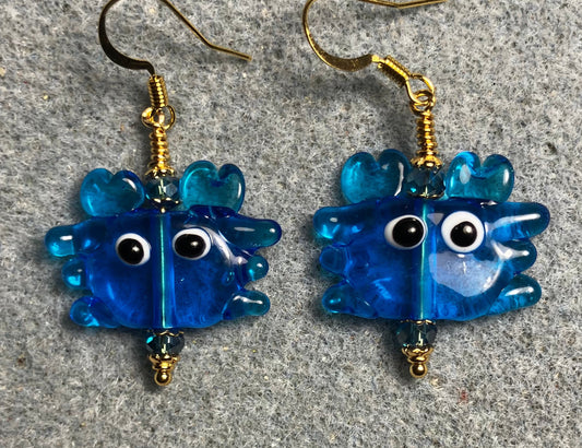 Turquoise blue lamp work crab bead earrings adorned with turquoise blue Chinese crystal beads.