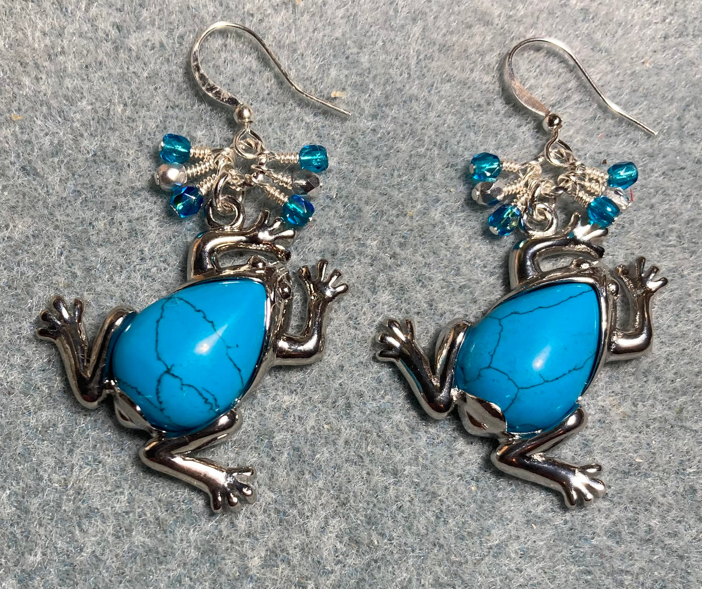 Large silver and turquoise gemstone frog charm earrings adorned with small dangling turquoise and silver Czech glass beads.