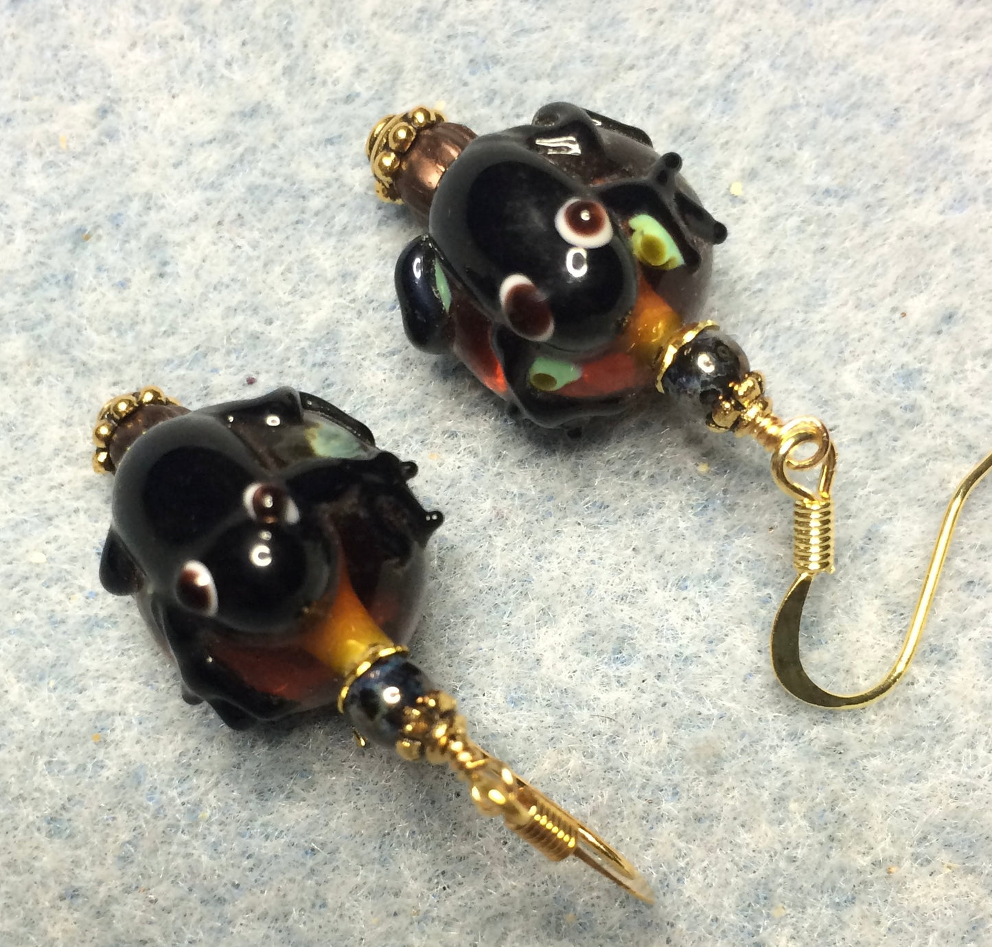 Brown and green lamp work frog bead earrings adorned with brown Czech glass beads.