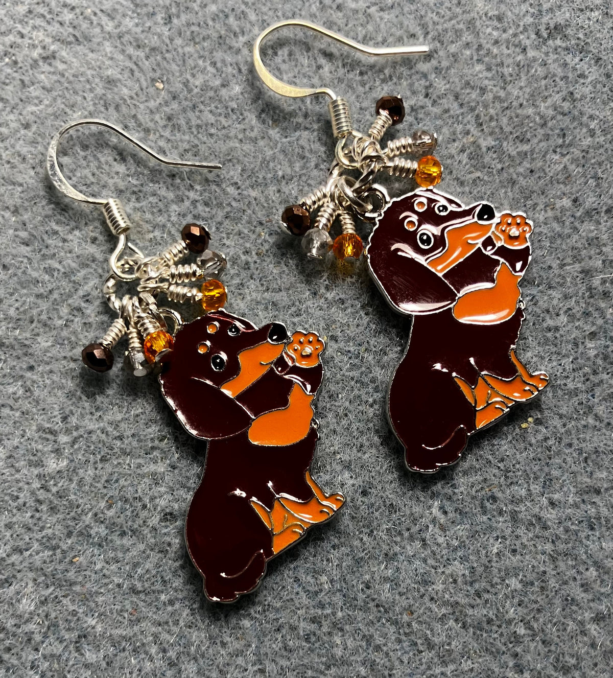 Large brown and orange enamel dachshund charm earrings adorned with tiny dangling brown, orange, and silver Chinese crystal beads.