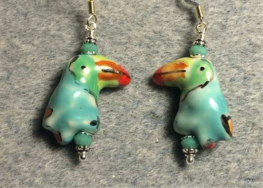 Turquoise green ceramic toucan bead earrings adorned with turquoise green Chinese crystal beads.