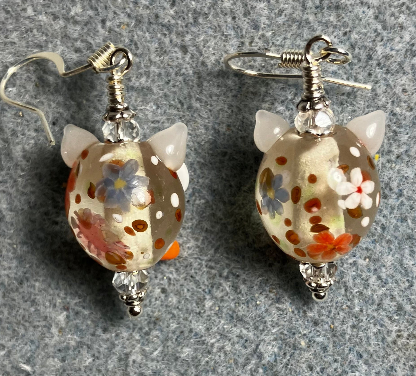 Clear, orange, and red lamp work owl bead earrings adorned with clear Chinese crystal beads.