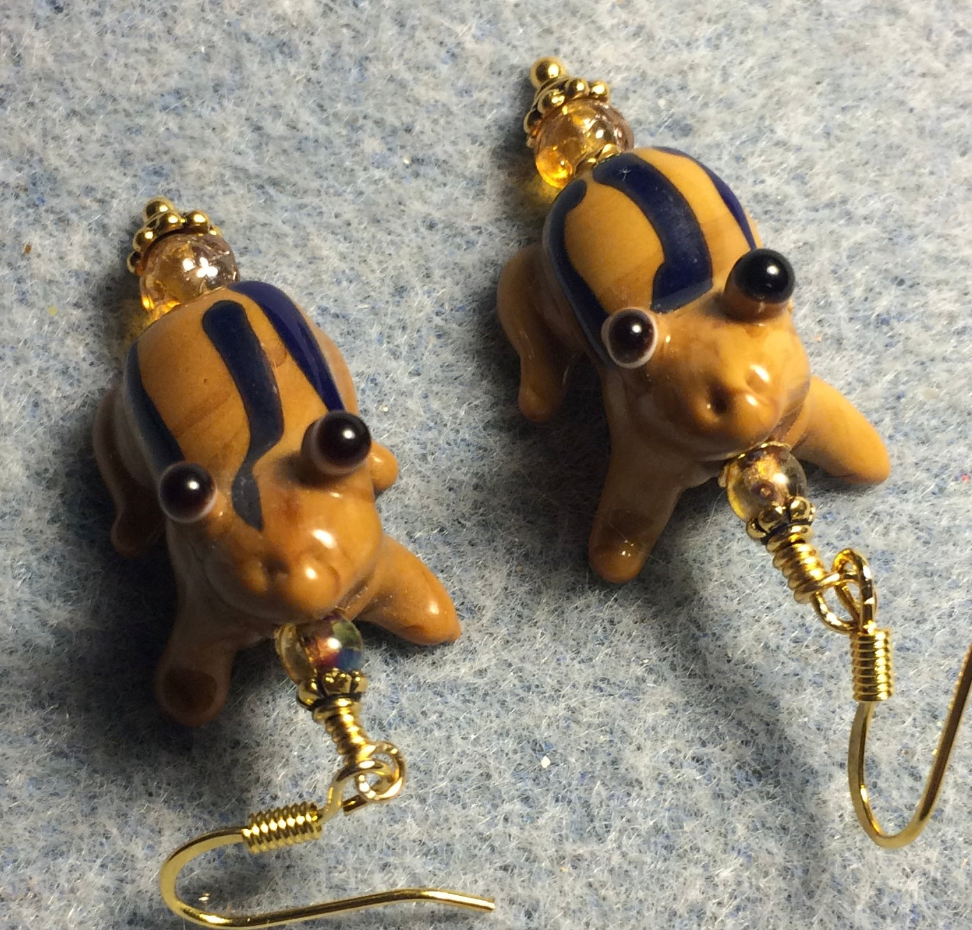 Brown and blue lamp work striped frog bead earrings adorned with amber Czech glass beads.