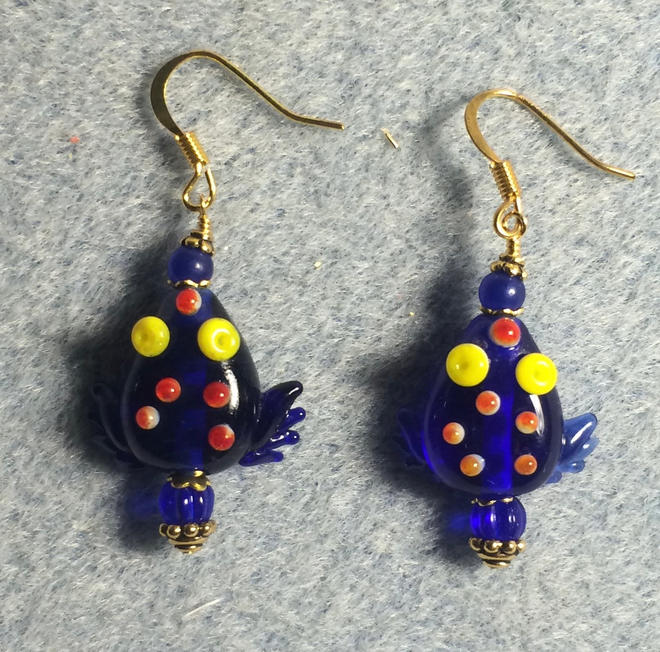 Transparent dark blue lamp work frog bead earrings adorned with dark blue Czech glass beads.