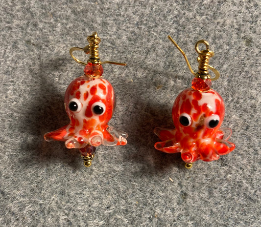 Red and white mottled lamp work octopus bead earrings adorned with red Chinese crystal beads.