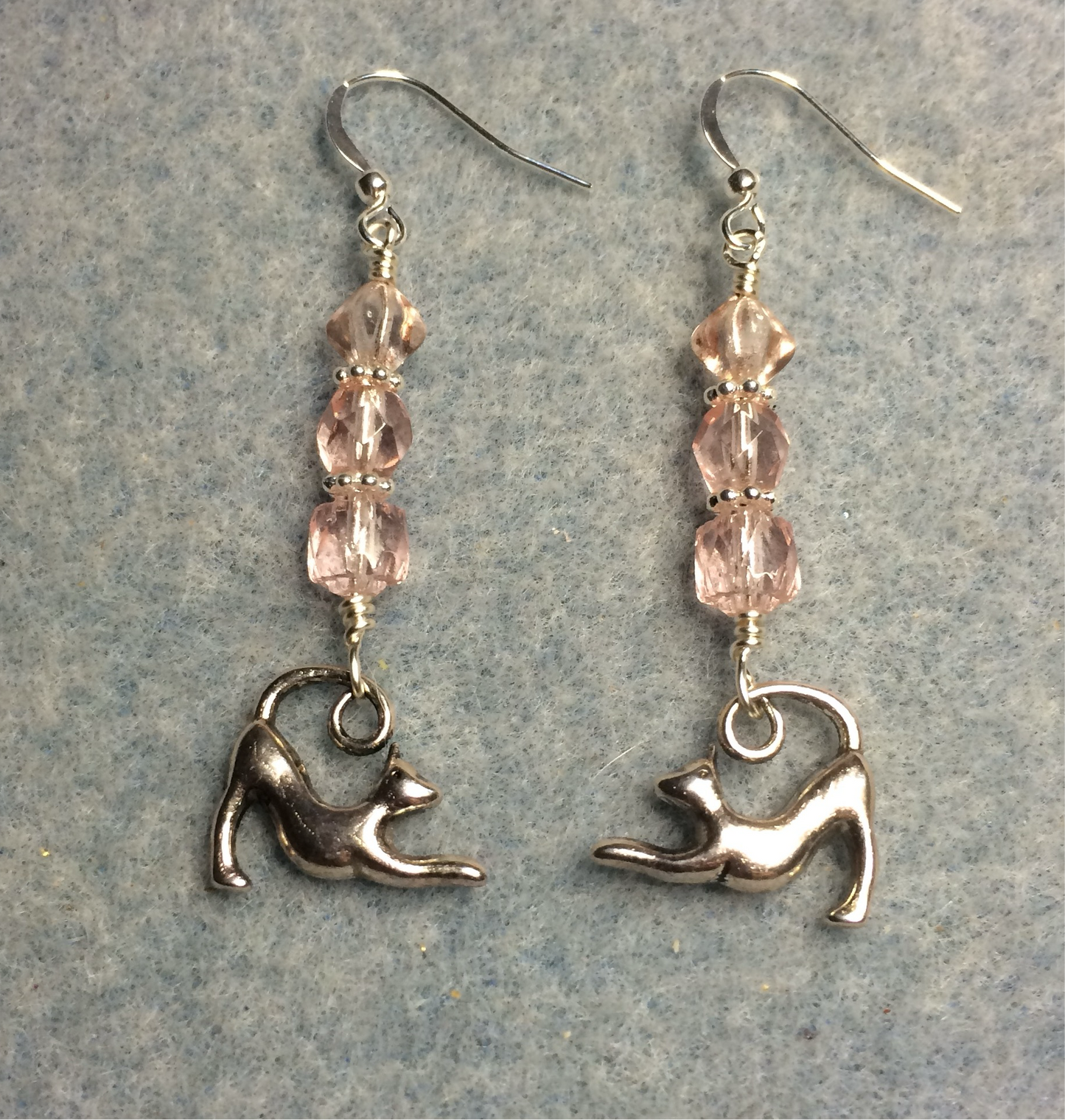 Silver stretching cat charm earrings adorned with light pink Czech glass beads