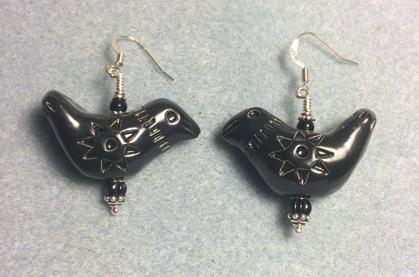 Large black ceramic songbird bead earrings adorned with black Czech glass beads.