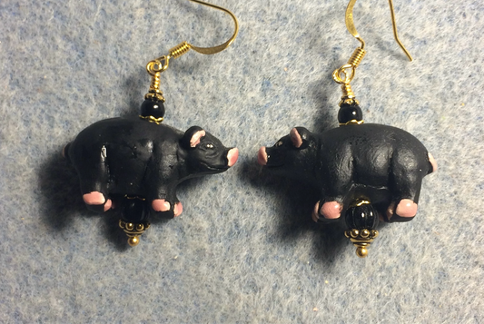 Large black and pink ceramic pig bead earrings adorned with black Czech glass beads.
