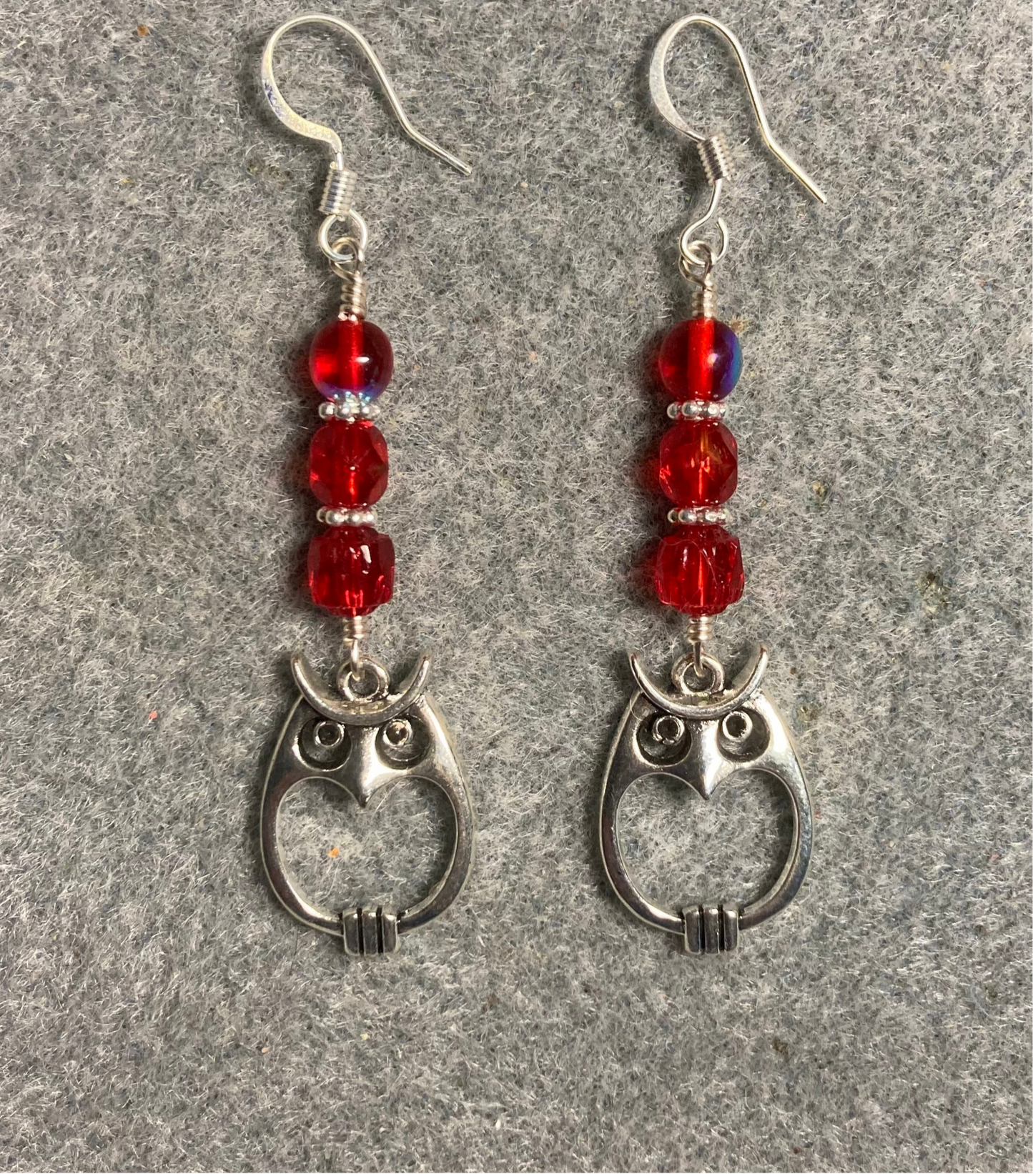 Silver owl charm earrings adorned with red Czech glass beads.