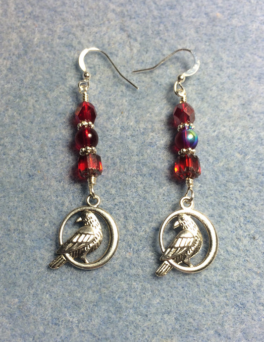 Silver raven charm earrings adorned with red Czech glass lentil beads.