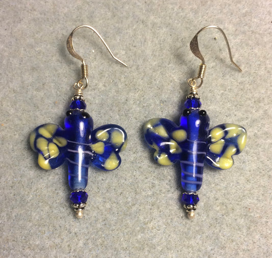Dark blue and yellow lamp work dragonfly bead earrings adorned with dark blue Chinese crystal beads.