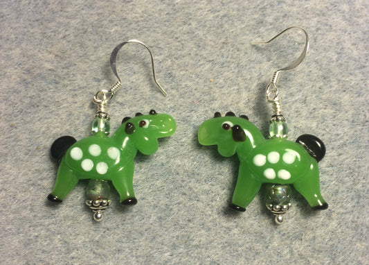 Opaque bright green lamp work spotted horse bead earrings adorned with green Czech glass beads.