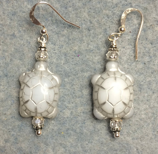 White (with silver inlay) Czech glass turtle bead earrings adorned with clear Chinese crystal beads.