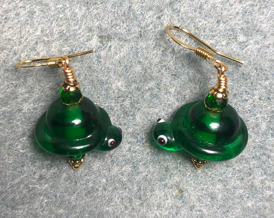 Emerald green lamp work turtle bead earrings adorned emerald green beads.