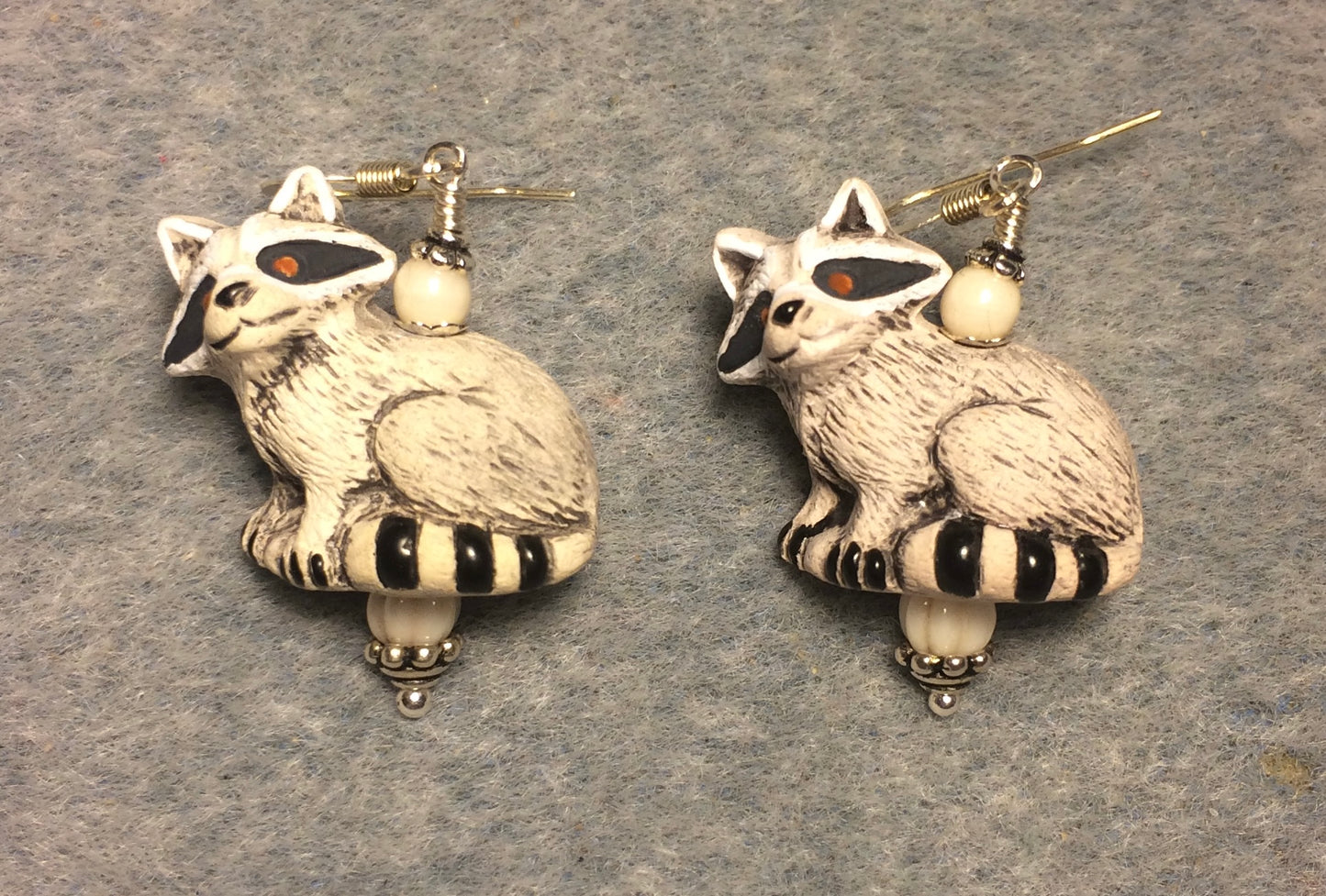 Large light gray and black ceramic raccoon bead earrings adorned with white Czech glass beads.