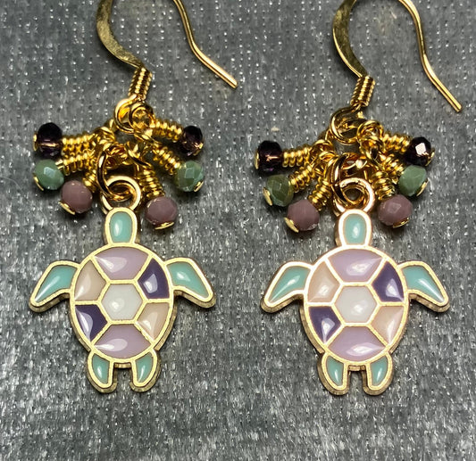 Purple, light green, and violet enamel sea turtle charm earrings adorned with tiny dangling purple, light green, and violet Chinese crystal beads.