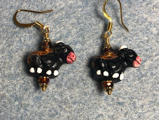 Small black, brown, and red ceramic cow bead earrings adorned with small brown Chinese crystal beads.