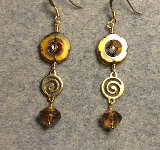 Translucent topaz Czech glass pansy bead earrings adorned with gold swirly connectors and translucent topaz Czech glass Saturn beads.