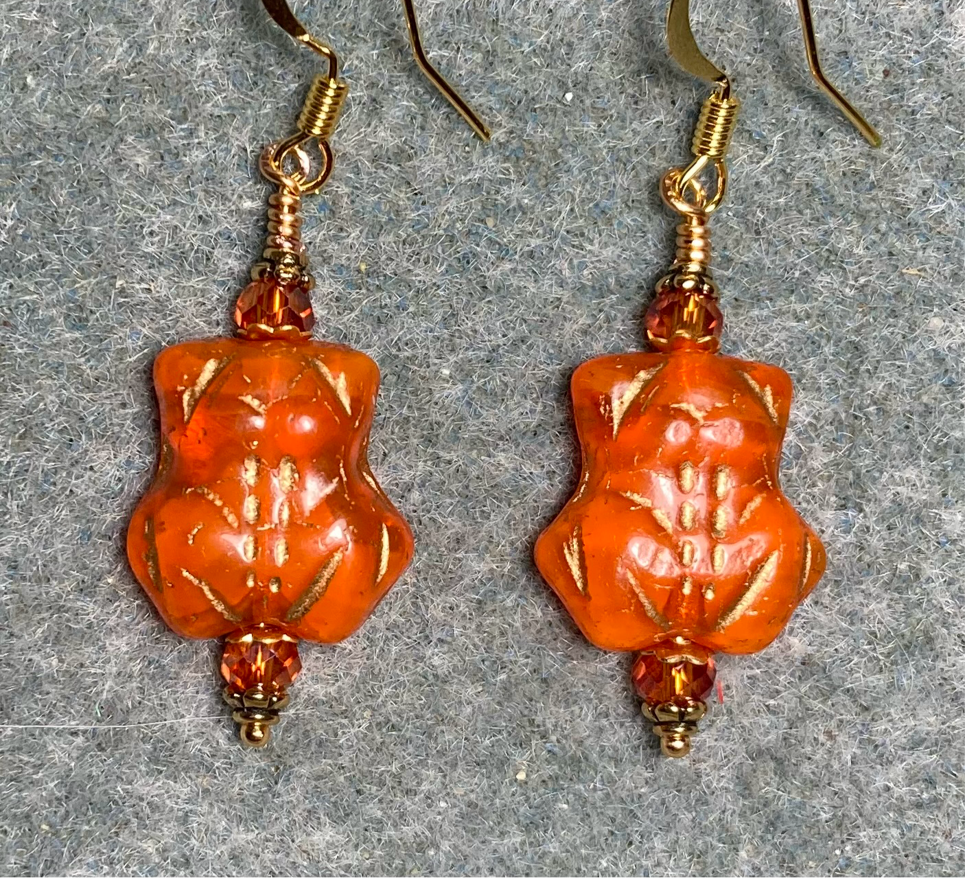 Orange (with gold inlay) Czech glass frog bead earrings adorned with orange Chinese crystal beads.