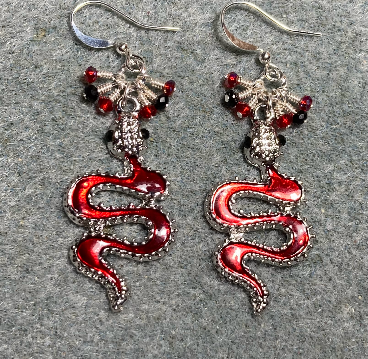 Red enamel coiled snake charm earrings adorned with tiny dangling red and silver Chinese crystal beads.