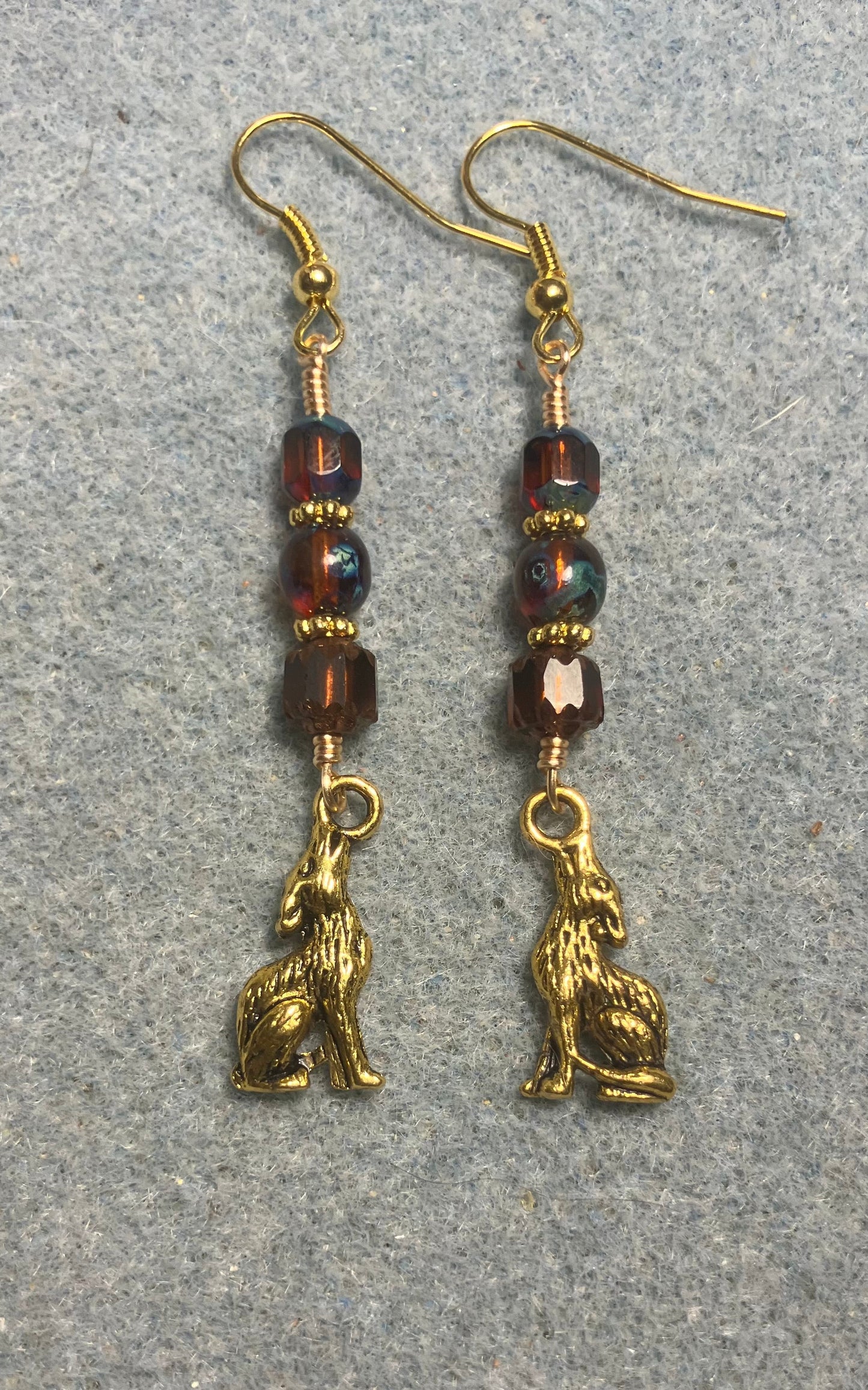 Gold howling coyote charm earrings adorned with brown Czech glass beads