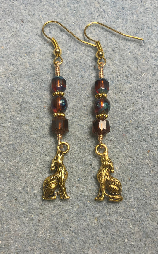 Gold howling coyote charm earrings adorned with brown Czech glass beads