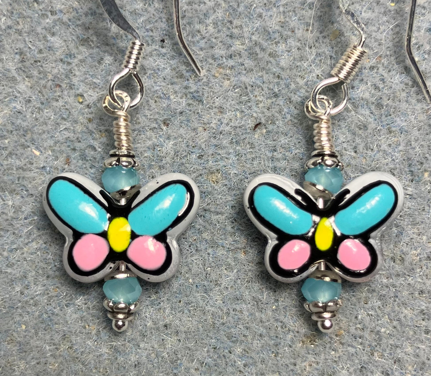 Small turquoise, pink, and yellow ceramic butterfly bead earrings adorned with turquoise Chinese crystal beads.