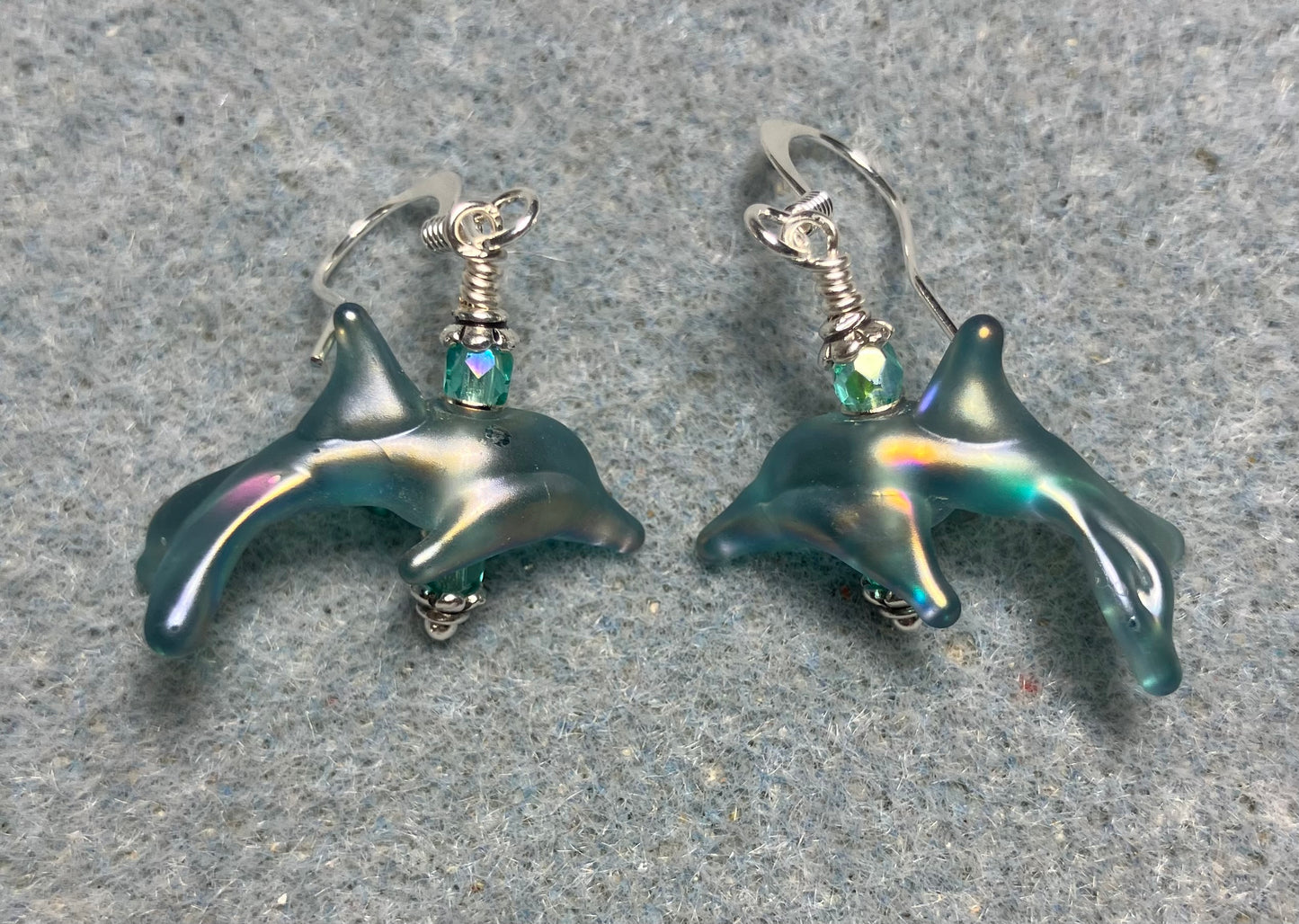 Tiny matte teal lamp work dolphin bead earrings adorned with tiny teal Chinese crystal beads.