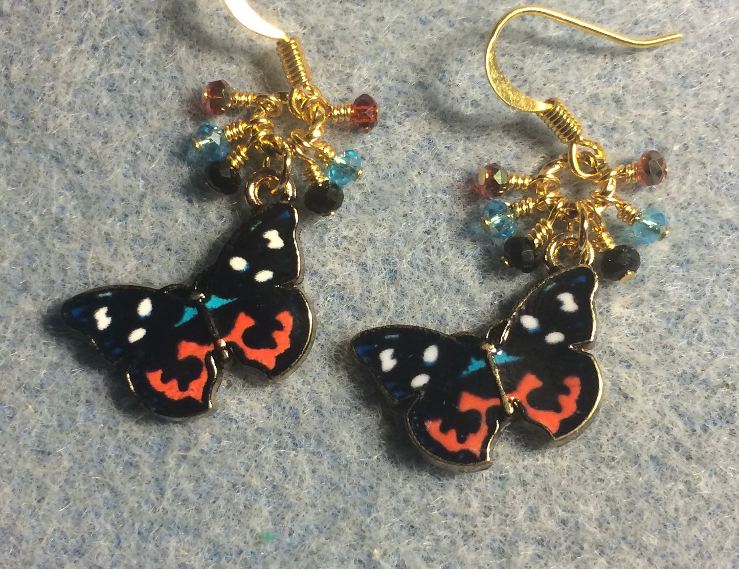 Black, red, and turquoise enamel butterfly charm earrings adorned with tiny dangling black, red, and turquoise Chinese crystal beads.