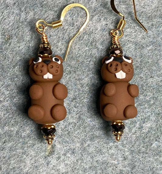 Brown and white polymer clay beaver bead earrings adorned with brown Chinese crystal beads.