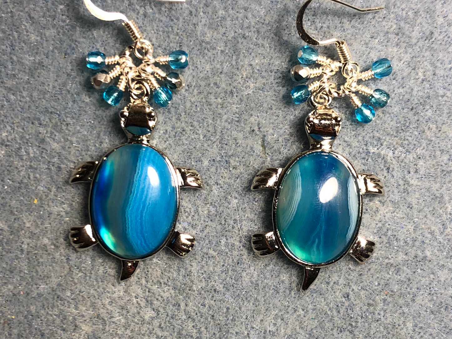 Large silver and blue striped agate gemstone turtle charm earrings adorned with small dangling turquoise and silver Czech glass beads.