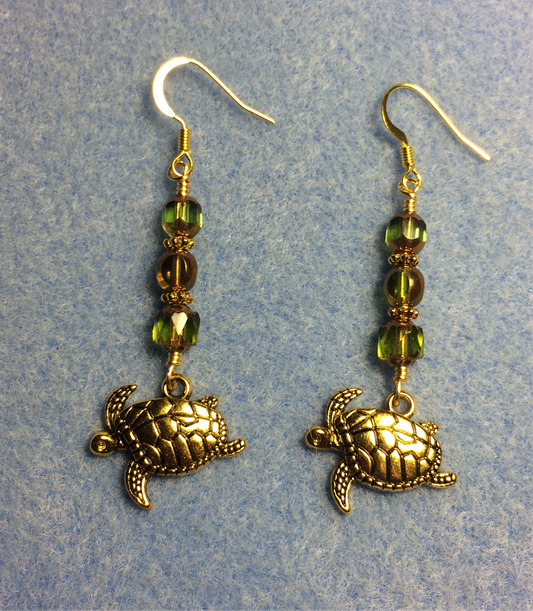 Gold sea turtle charm earrings adorned with olive green Czech glass beads