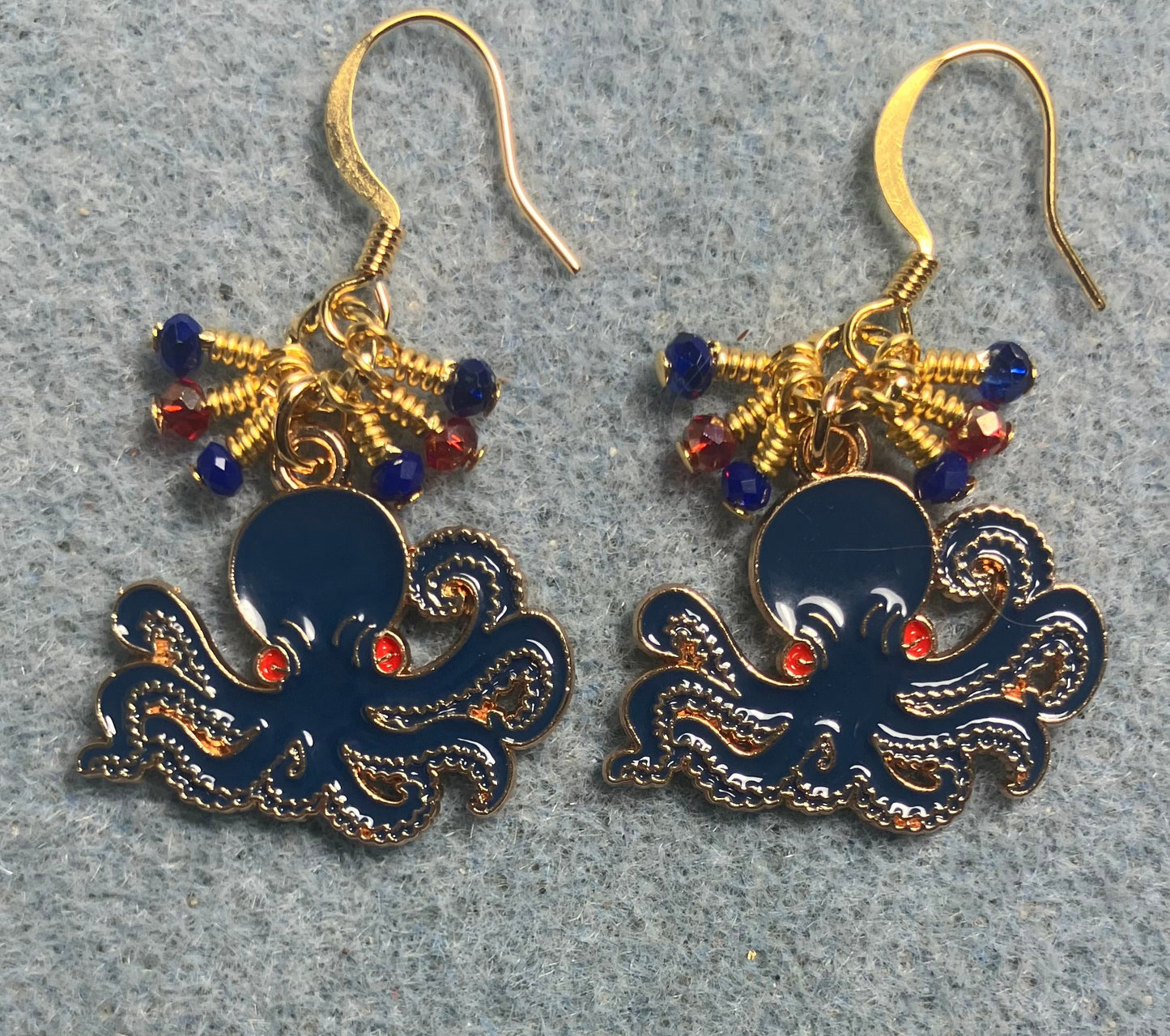 Dark blue, red, and gold enamel octopus charm earrings adorned with tiny dangling dark blue and red Chinese crystal beads.