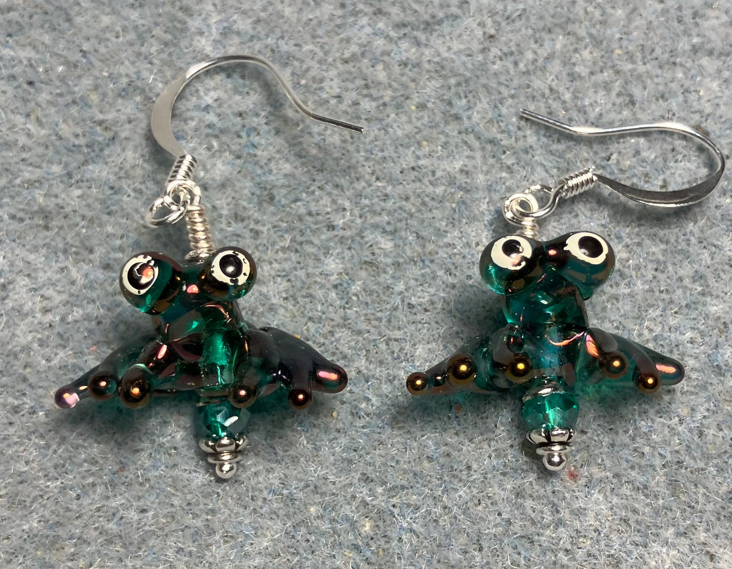 Tiny aurora borealis teal lamp work frog bead earrings adorned with tiny teal Chinese crystal beads.