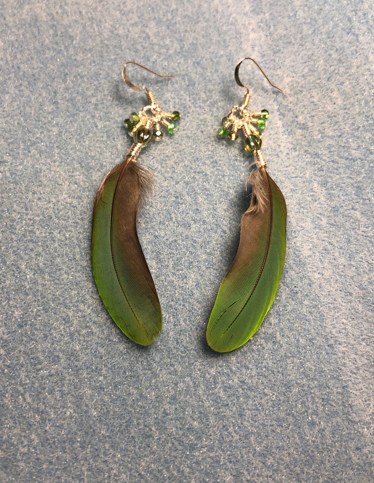 Lime green parrot feather earrings adorned with green Czech glass melon beads and tiny dangling green Chinese crystal beads.