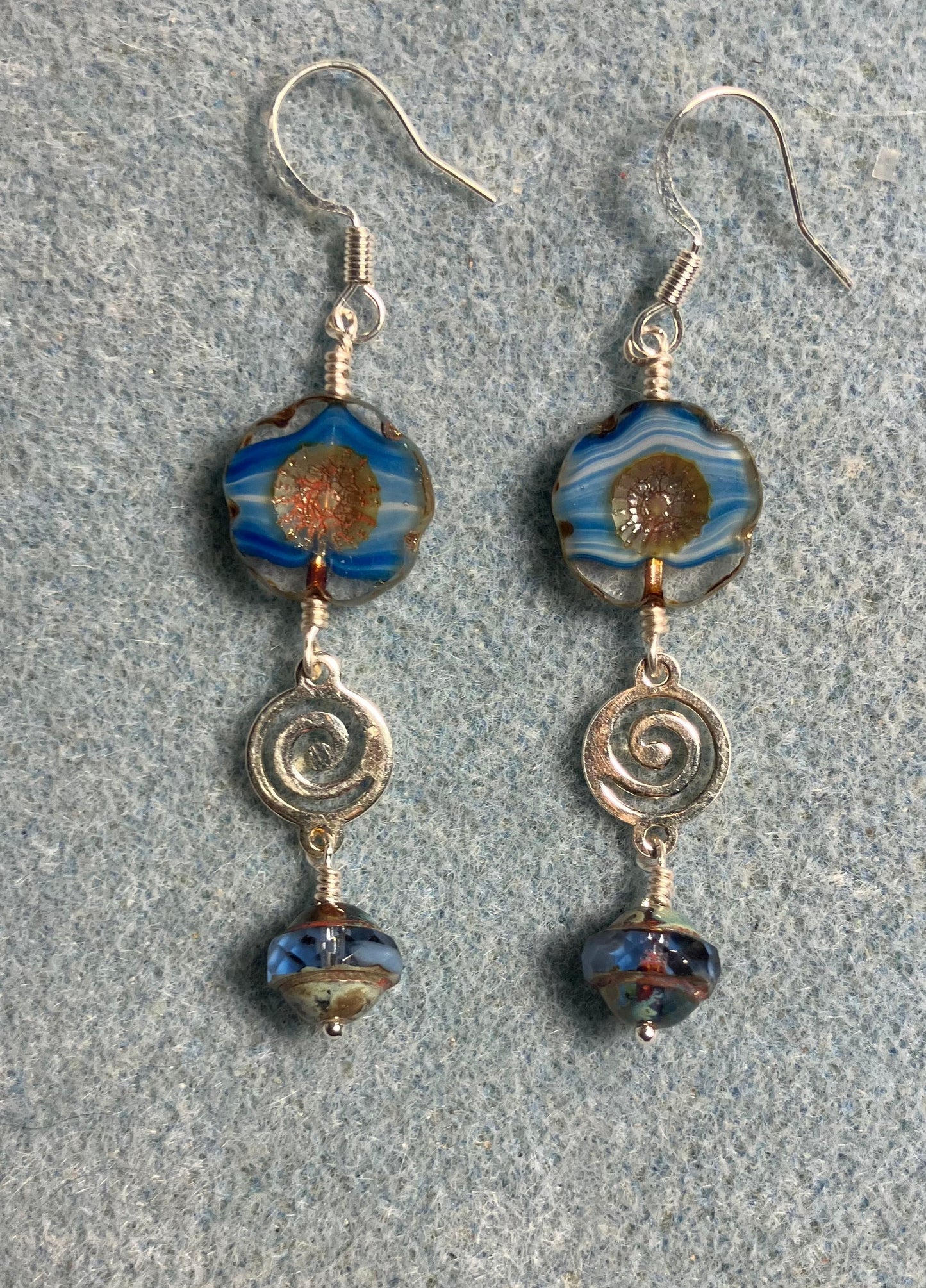 Blue striped Czech glass pansy bead earrings adorned with silver swirly connectors and blue Czech glass Saturn beads.