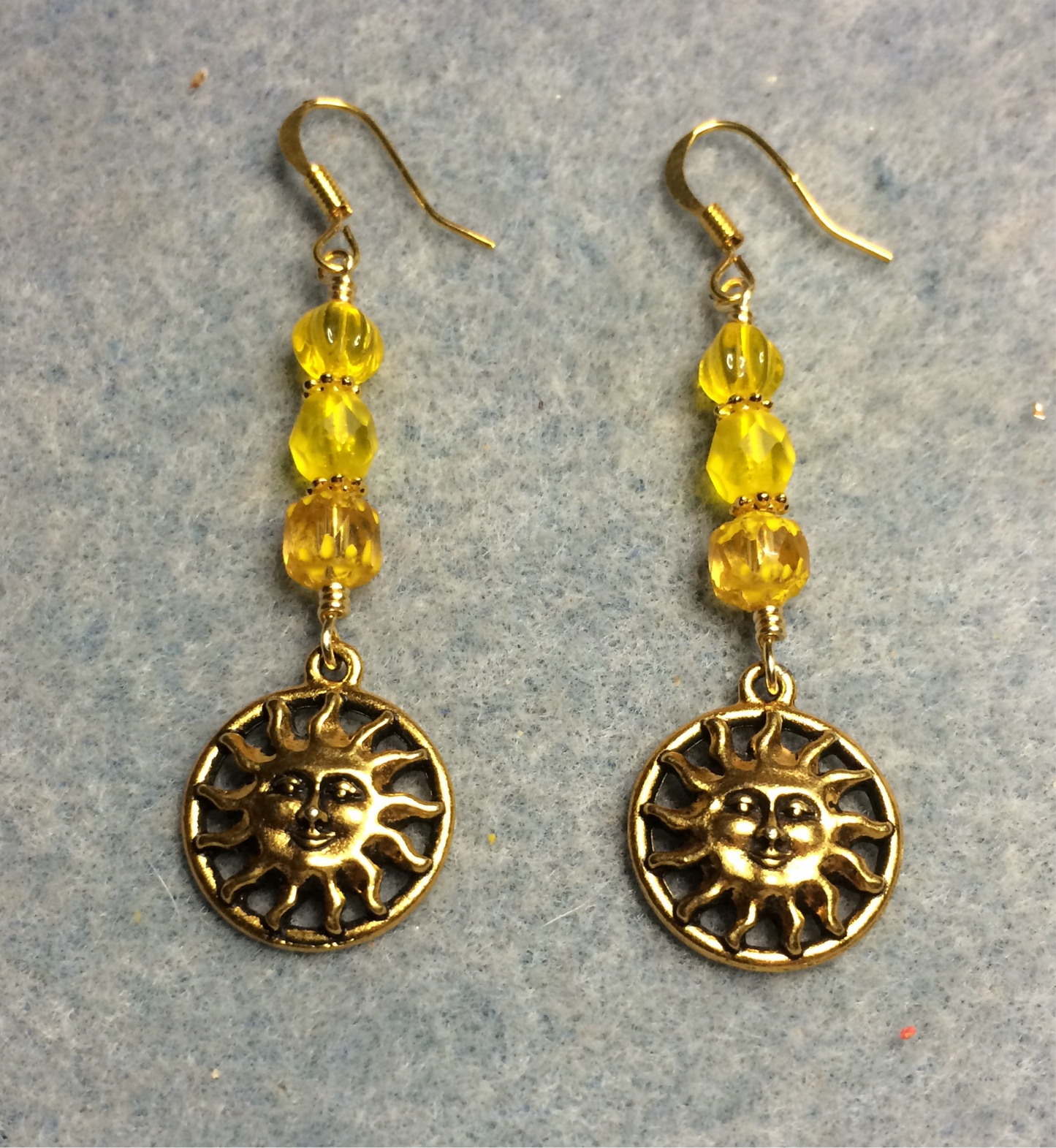 Gold sun charm earrings adorned with bright yellow Czech glass beads