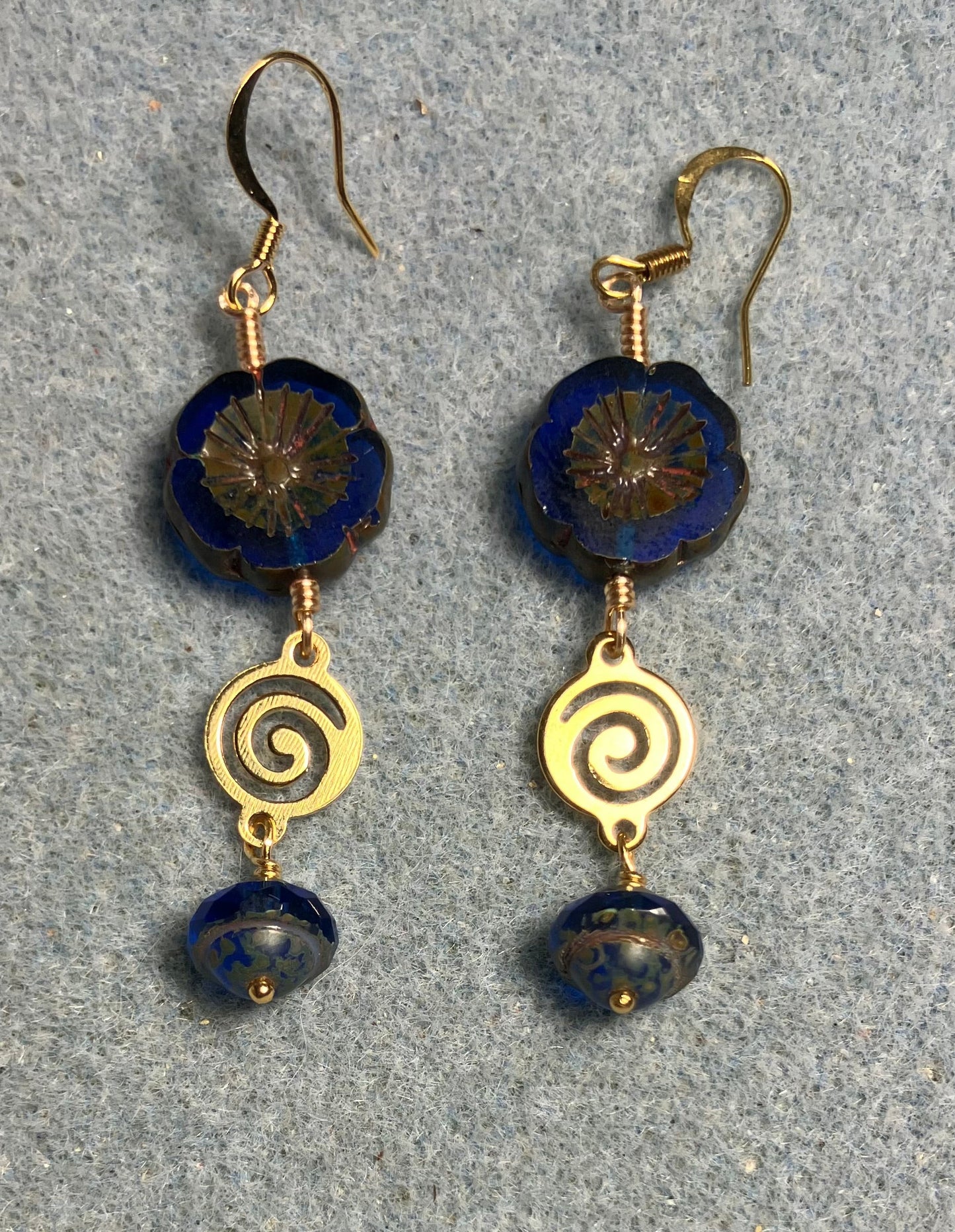 Cobalt blue Czech glass pansy bead earrings adorned with gold swirly connectors and cobalt blue Czech glass Saturn beads.