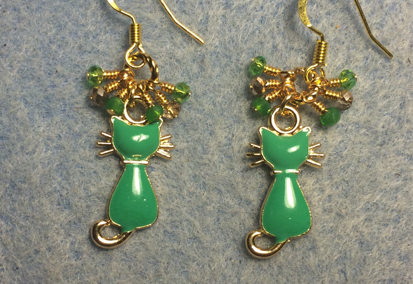 Small green and gold enamel cat charm earrings adorned with tiny dangling green and gold Chinese crystal beads.