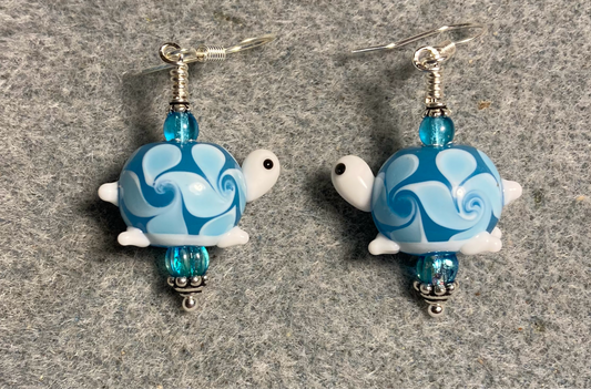 Light turquoise lamp work turtle bead earrings adorned with light turquoise Czech glass beads.