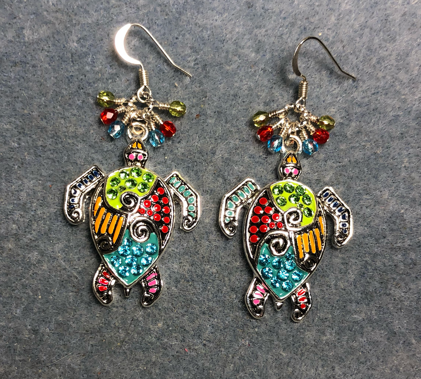 Large silver and colorful rhinestone sea turtle charm earrings adorned with small dangling turquoise, red, and olive green Czech glass beads.