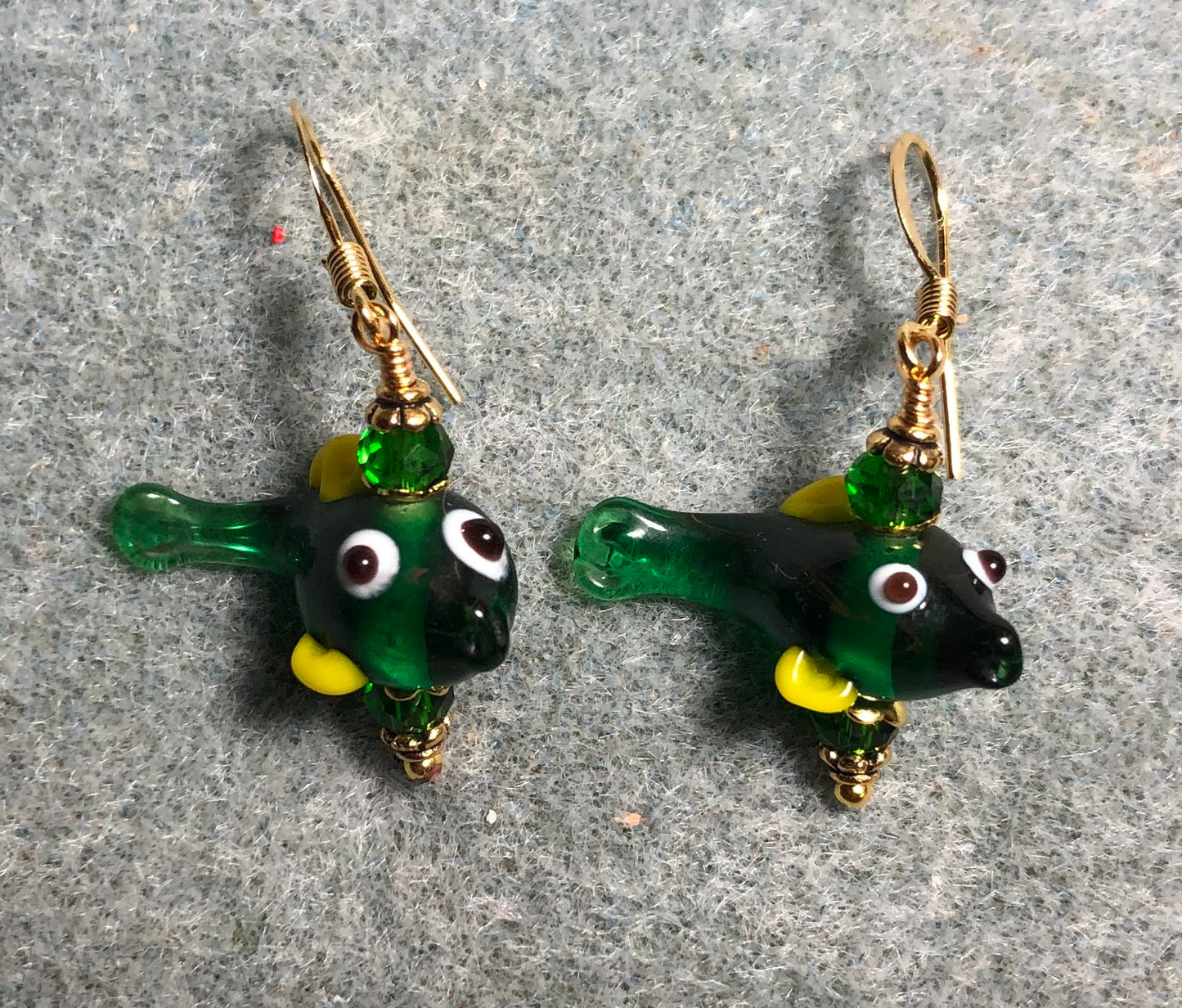 Small emerald green and yellow lamp work fish bead earrings adorned with emerald green Chinese crystal beads.