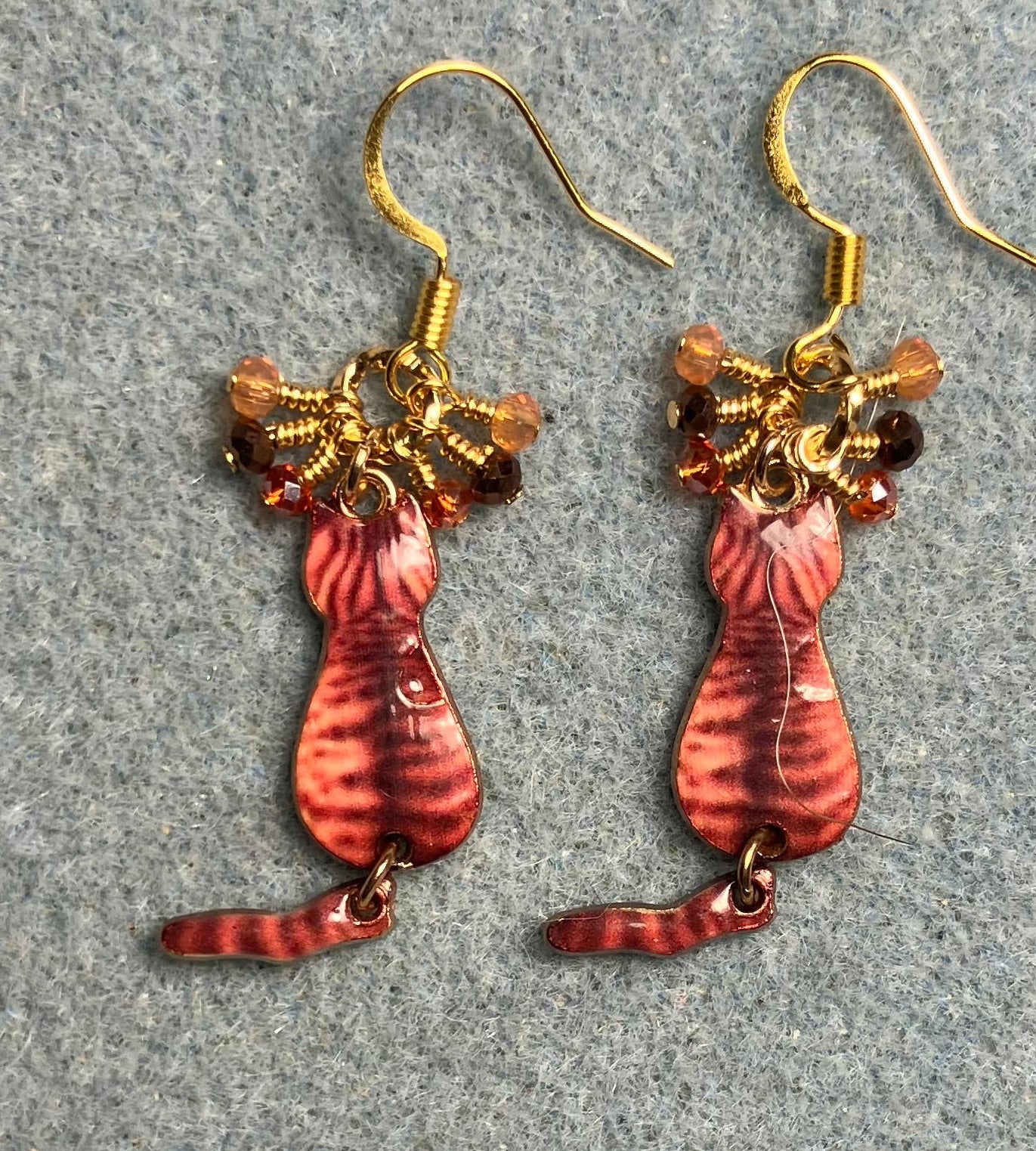 Orange and brown enamel tabby cat charm earrings adorned with tiny dangling orange and brown Chinese crystal beads.