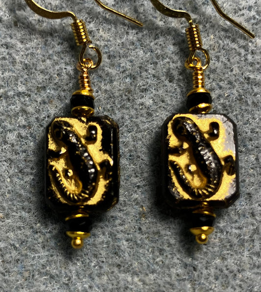Small black and gold Czech glass lizard bead earrings adorned with black Chinese crystal beads.