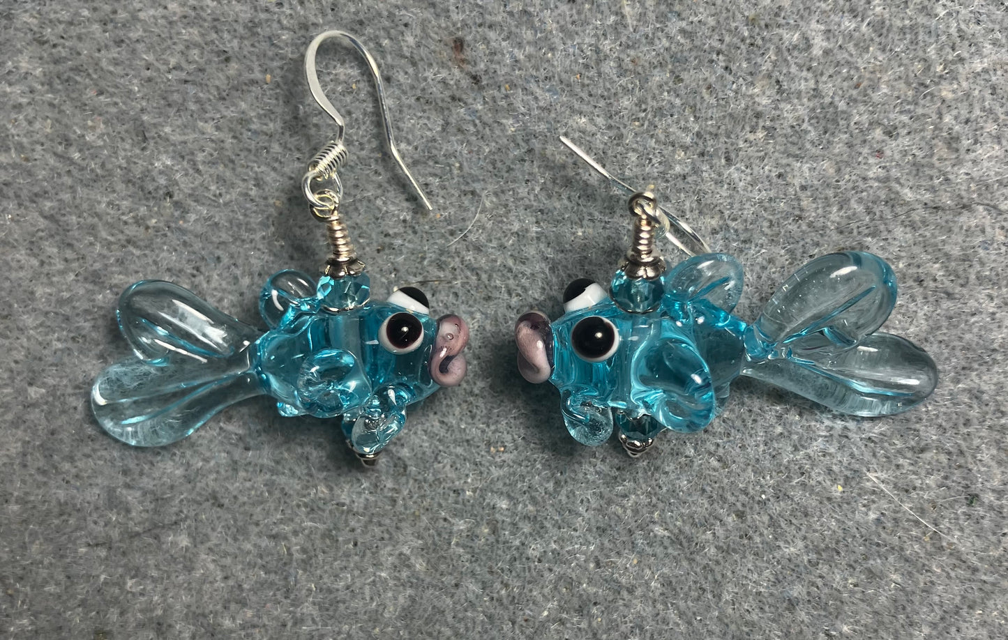 Translucent light turquoise lamp work fish bead earrings adorned with light turquoise Chinese crystal beads.