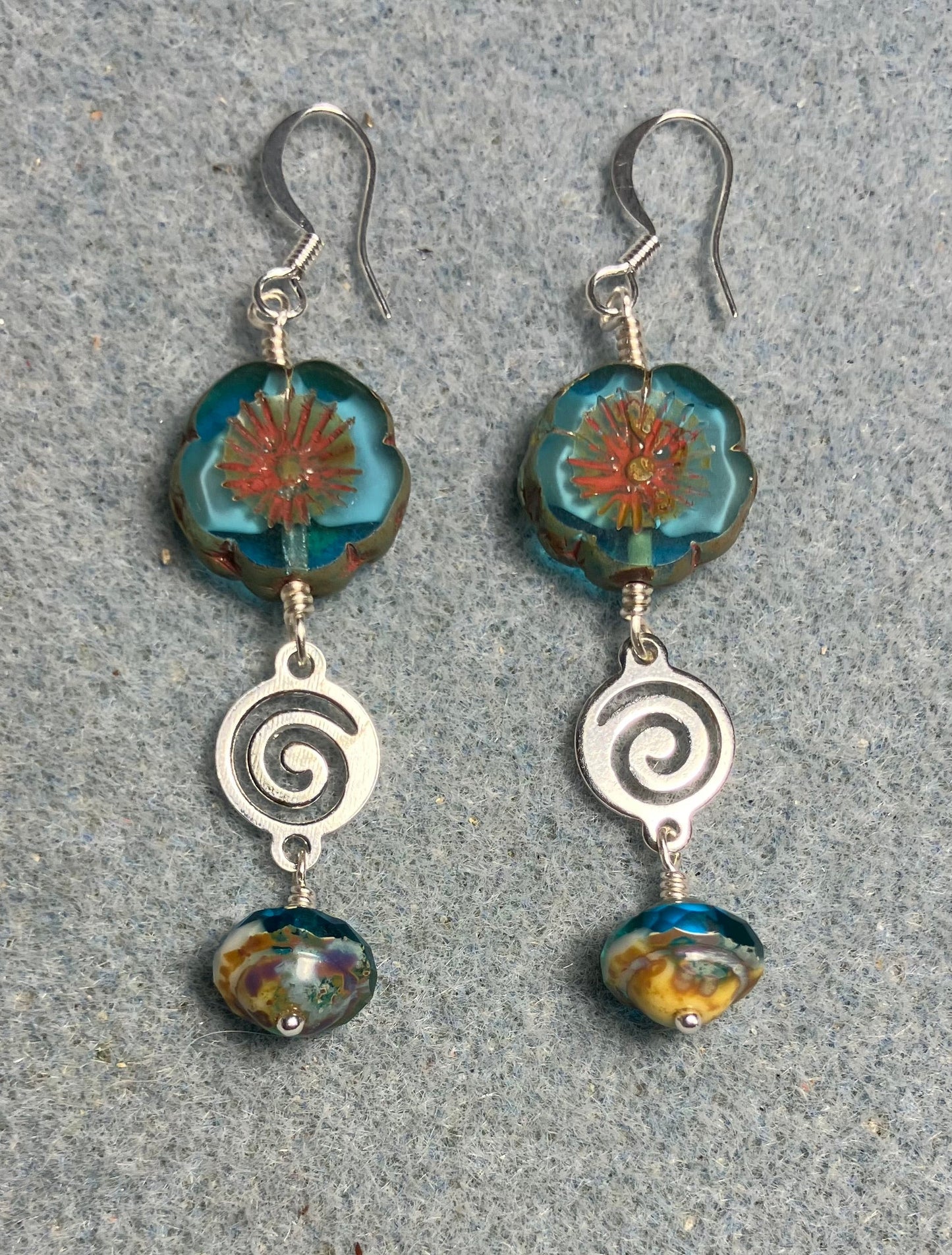Turquoise and white Czech glass pansy bead earrings adorned with silver swirly connectors and turquoise Czech glass Saturn beads.